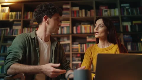 Red-haired female scientist and male colleague discussing library research Stock Footage 340266817