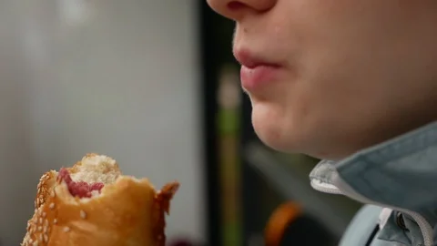 Red-haired girl eats a loaf leaving crumbs on her face Stock Footage 112973339