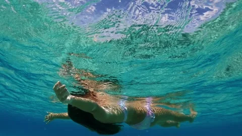 Red-haired girl floating with open arms in sea Stock Footage 279435581