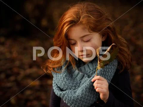 Red haired girl holding autumn leaf Stock Photos