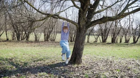 Red-haired girl is playing in a spring park Stock Footage 74227467