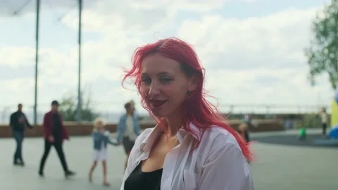 Red-haired girl with ring in her nose smiling on the street in a sunny day Stock Footage 160984959