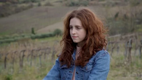 Red-haired girl throws her hair back and smiles at the background of the vineyar Stock Footage 99097611