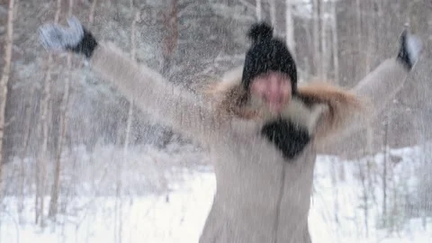 Red-haired girl throws snow to the top, smiling, and dancing in winter forest Stock Footage 167951693