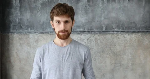 Red-haired guy clapping on a gray wall background Stock-Footage 82497018