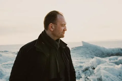 Red haired guy on a lake in winter in the sunset Stock Photos