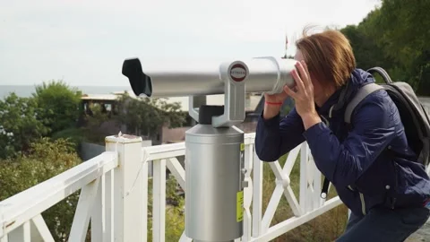 Red-haired guy looking through binoculars.against the blue sky Stock-Footage 163419088