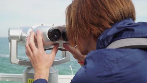 Red-haired guy looking through binoculars.against the blue sky Vidéo 163419165