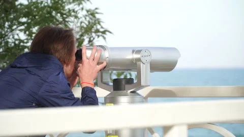 Red-haired guy looking through binoculars.against the blue sky 스톡 동영상 163419231