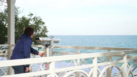 Red-haired guy looking through binoculars.against the blue sky Stock-Footage 163448275