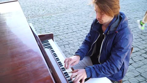 Red-haired guy playing the piano in a blue jacket on the street Vidéo 163350437