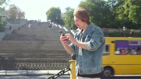 Red-haired guy rejoices on the background of the stairs Vidéo 163364184