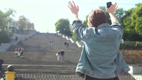 Red-haired guy talking on the phone and waving to someone Vidéo 163364272