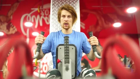 Red-haired guy worked out the training apparatus in the red gym.close-up Stock Footage 163458597
