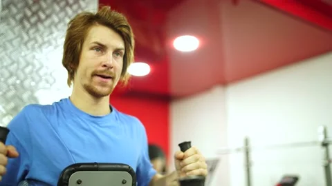 Red-haired guy worked out the training apparatus in the red gym.close-up Stock-Footage 163459102