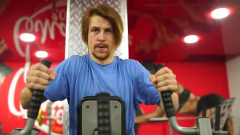 Red-haired guy worked out on the training apparatus in the red gym.close-up Stock-Footage 163459470