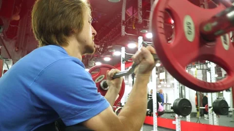 Red-haired guy worked out on the training apparatus.lifts the barbell 動画素材 163459655