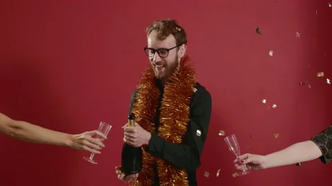 Red-haired handsome man in glasses and a golden boa raises a glass of champagne. Stock Footage 221642950