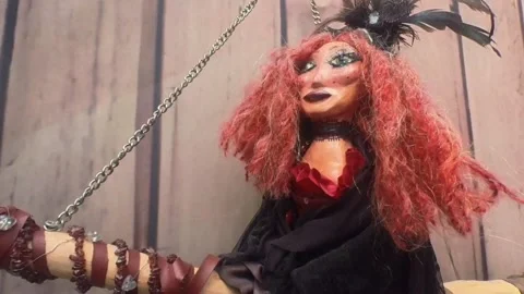 Red haired magical witch riding broomstick hanging by fine chain Stock Footage 328233315