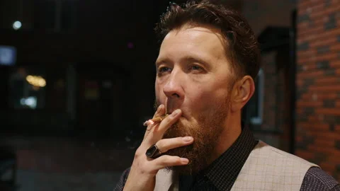 Red-haired middle-aged man having cigarette in yard Video stock 232523587