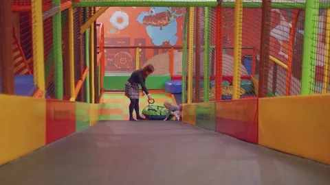 Red haired mom and blond son climb slide dagging tube Stock Footage 84414888