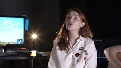 Red-haired singer singing in a music studio. Closeup Stock Footage 138463476