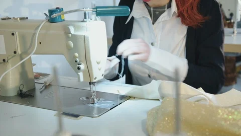 The red-haired tailor sewing clothes, using sewing machine Stock Footage 105243990