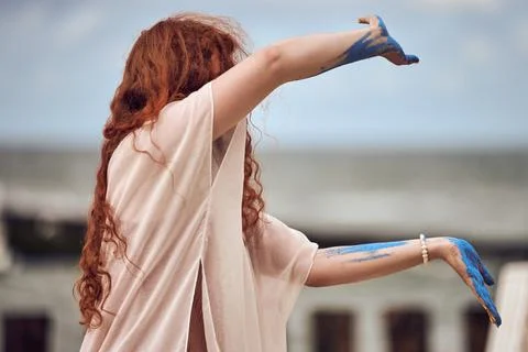 Red haired woman dancing performance on sea beach, beautiful meditative dance Stock Photos