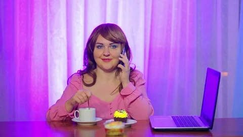 Red-haired woman at a table in a cafe bothers with a spoon of coffee and talking Vidéo 119923968