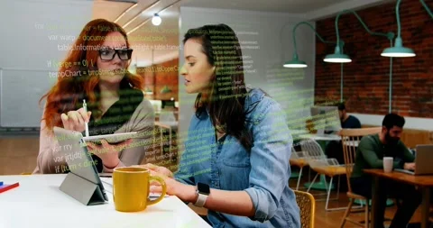 Red-haired woman tapping tablet, brunette typing laptop reviewing code, overlay Stock Footage 329946304