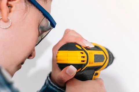 Red-haired woman using a drill at home Stock Photos