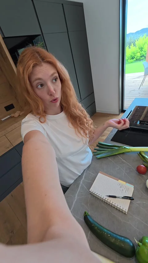 Red-Haired Woman Vlogging While Arranging Fresh Healthy Vegetables in a Bright M 스톡 동영상 333542531