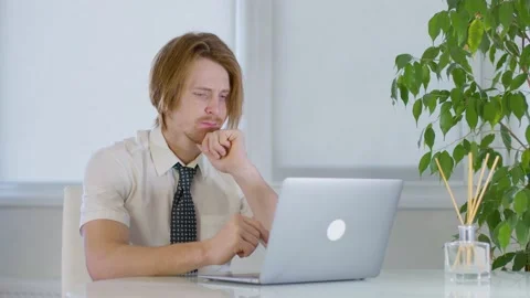 Red-haired young male worker in the office.does not understand what say in call Vidéo 239270353