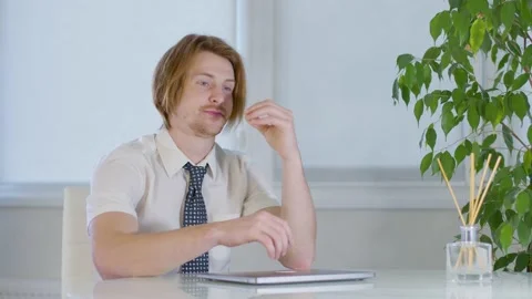 Red-haired young male worker the office.frustrated closes laptop.not understand Vidéo 239270539