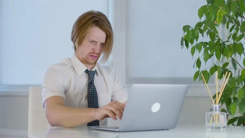 Red-haired young male worker in the office.annoying on laptop.state of shock Vidéo 239271252