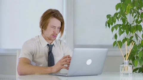 Red-haired young male worker in the office.abruptly closes the laptop.fright Vidéo 239271470