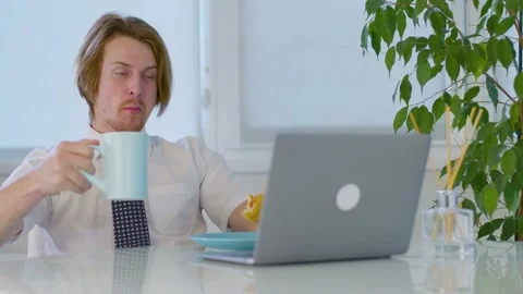 Red-haired young male worker lunch burger in office.eating in laptop at work 動画素材 239272464