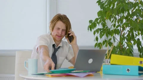 Red-haired young male worker in the office.rubbish on the table documentation Vidéo 239272928