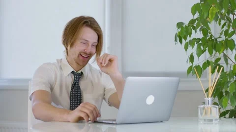 Red-haired young male worker in office.laughing at laptop.cheerful happy worker Vidéo 239273337