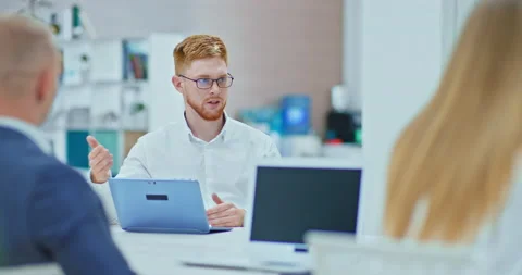 Red-haired young man in glasses is conducting business negotiations with Stock Footage 138774305