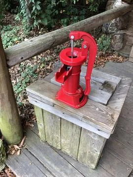 Red Hand Pump In Front Of Log Cabin At Columbus Zoo And Aquarium Stock Photos