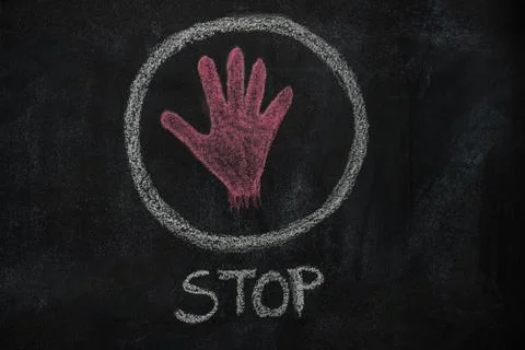 Red hand shape and stop word in the circle on black chalkboard Stock Photos