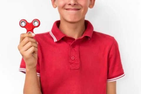 Red hand spinner. Boy playing a popular toy fidget spinner in his hand. Stres Stock Photos