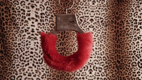 Red handcuffs on a leopard background Stock Footage 151841388