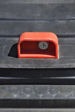 Red handle with a key lock on a black plastic surface Stock Photos