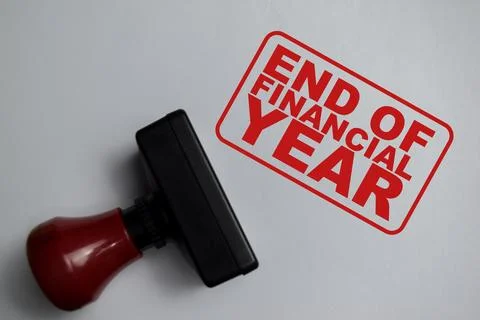 Red Handle Rubber Stamper and end of financial year text above book Photos