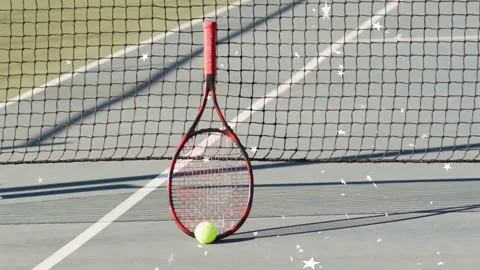 Red-handled racket leaning against net and ball resting, frames causing sparkle Stockbeeldmateriaal 333004646