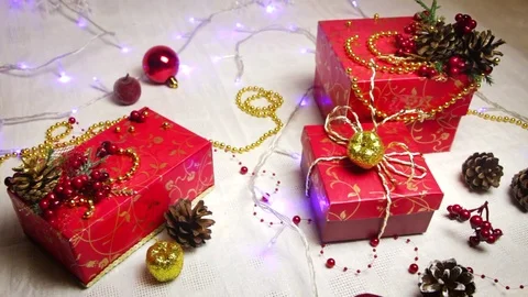 Red handmade gift boxes and Christmas decorations, golden apples and bumps with Video stock 82406631