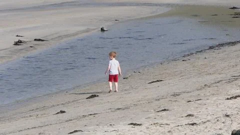 Red headed boy playing on a sandy beach in Northern Ireland Holidays UK Stock-Fotos
