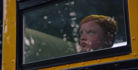 Red headed kid looking out window longingly Stock Footage 53400908